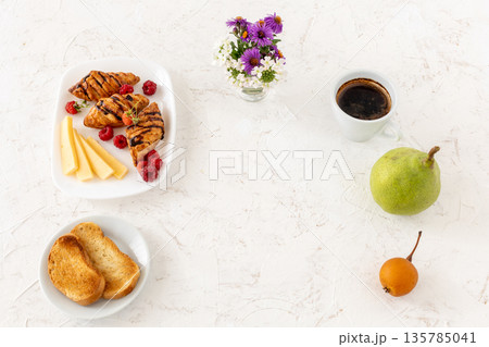 Croissants. sliced cheese and raspberries with a cup of coffee. 135785041
