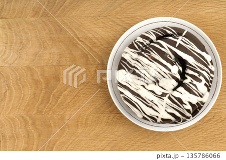bun covered with chocolate, on a wooden board bun covered with chocolate, on a wooden board 135786066
