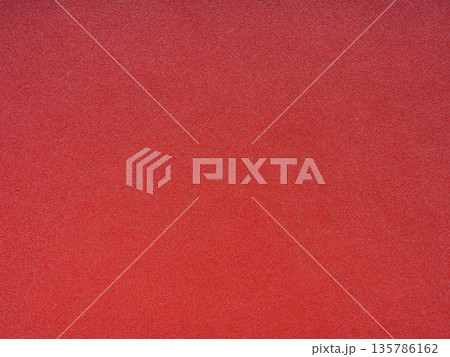 Vivid crimson whispers softly in this intimate close-up of a textured paper surface Vivid crimson whispers softly in this intimate close-up of a textured paper surface 135786162