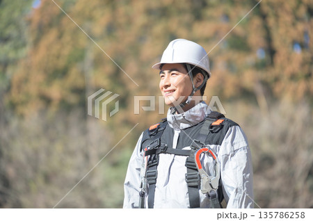 工事現場でヘルメットを被る日本人男性 工事現場でヘルメットを被る日本人男性 135786258