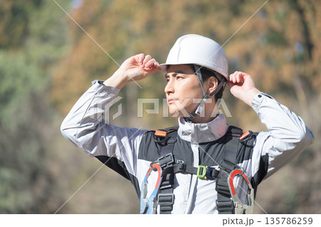 工事現場でヘルメットを被る日本人男性 135786259