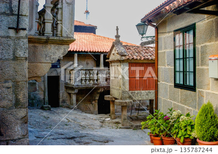 A small courtyard with a red building and a white building 135787244