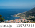 A beautiful blue ocean with a small town in the background 135787248