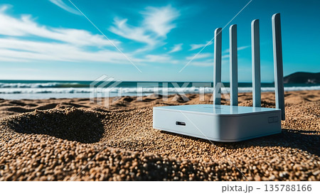 Wi-Fi router with antennas on a sandy beach with ocean waves and blue sky 135788166