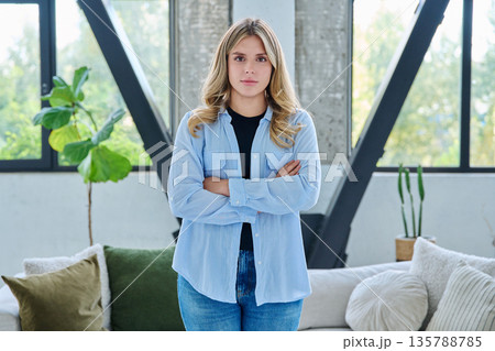Portrait of young confident smiling woman in home interior Portrait of young confident smiling woman in home interior 135788785
