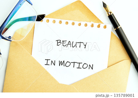 A profound message BEAUTY IN MOTION unfolds on a white sheet from a brown envelope A profound message BEAUTY IN MOTION unfolds on a white sheet from a brown envelope 135789001