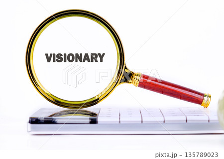 A golden and red magnifying glass clearly focuses on the bold word visionary against a clean white backdrop A golden and red magnifying glass clearly focuses on the bold word visionary against a clean white backdrop 135789023