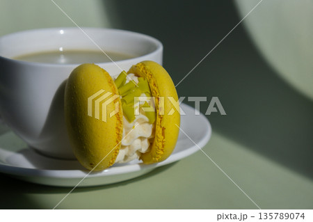 Sweet macaron dessert Cup of green plant based matcha tea latte in cozy morning atmosphere. Creative holiday romantic date idea. Herbal prebiotic fiber superfood beverage antioxidant-rich immunity Sweet macaron dessert Cup of green plant based matcha tea latte in cozy morning atmosphere. Creative holiday romantic date idea. Herbal prebiotic fiber superfood beverage antioxidant-rich immunity 135789074