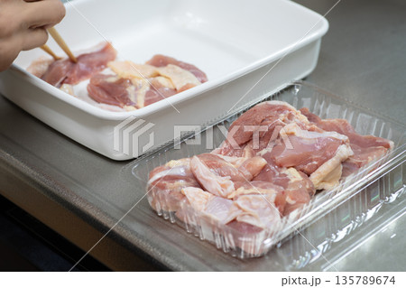鶏もも肉の下ごしらえをする女性の手元 135789674