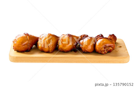 Grilled chicken drumsticks on a cutting board isolated. Fried crispy chicken legs on a cutting board isolated. Grilled chicken drumsticks on a cutting board isolated. Fried crispy chicken legs on a cutting board isolated. 135790152