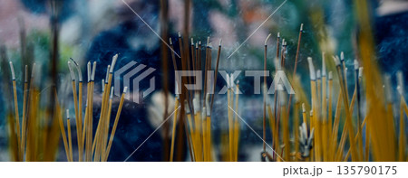 Incense sticks in a Buddhist temple close up. Burning sticks and smoke from incense burning and smoke 135790175