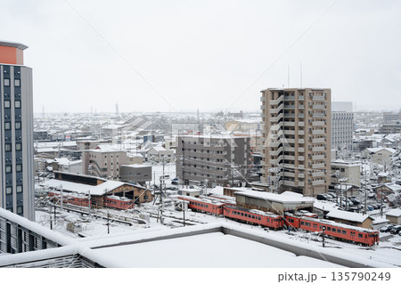 雪が積もったJR高岡駅とビルの屋上 雪が積もったJR高岡駅とビルの屋上 135790249