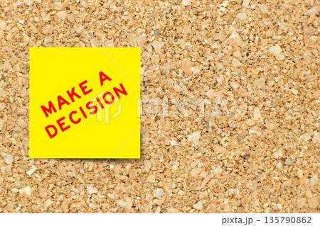 Yellow note paper with word make a decision on cork board background with copy space Yellow note paper with word make a decision on cork board background with copy space 135790862