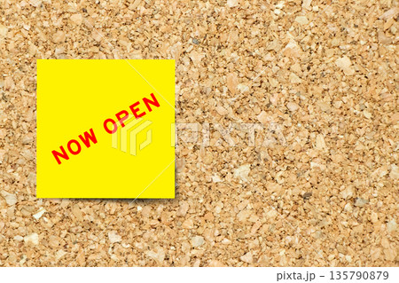 Yellow note paper with word now open on cork board background with copy space Yellow note paper with word now open on cork board background with copy space 135790879