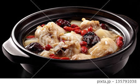 Chinese herbal chicken soup simmering in a black clay pot Chinese herbal chicken soup simmering in a black clay pot 135791038