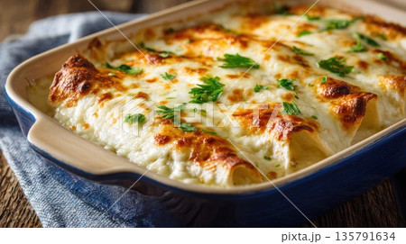 Delicious golden brown cannelloni with melted cheese is served 135791634