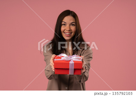 Happy Charming Woman Gift Box On PInk Background. Young Girl Smiling,Gives You Happy Charming Woman Gift Box On PInk Background. Young Girl Smiling,Gives You 135792103