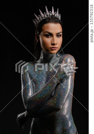Powerful woman in a crown with her body covered in shimmering holographic glitter Powerful woman in a crown with her body covered in shimmering holographic glitter 135792318