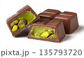 Dark chocolate pieces revealing vibrant pistachio filling 135793720