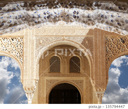 Arches in Islamic (Moorish)  style (against the background of a beautiful sky with clouds) in Alhambra, Granada, Spain 135794447
