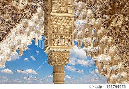 Arches in Islamic (Moorish) style (against the background of a beautiful sky with clouds) in Alhambra, Granada, Spain 135794476