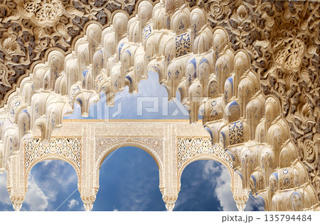Arches in Islamic (Moorish) style (against the background of a beautiful sky with clouds) in Alhambra, Granada, Spain 135794484