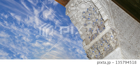 Arches in Islamic (Moorish) style (against the background of a beautiful sky with clouds) in Alhambra, Granada, Spain 135794518