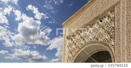 Arches in Islamic (Moorish) style (against the background of a beautiful sky with clouds) in Alhambra, Granada, Spain Arches in Islamic (Moorish) style (against the background of a beautiful sky with clouds) in Alhambra, Granada, Spain 135794520