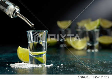 Tequila shots with lime slices and sea salt. Tequila shots with lime slices and sea salt. 135794565