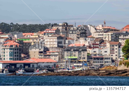 A city with a lot of buildings and a large body of water 135794717