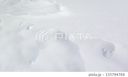 冬の雪原の起伏が広がるテクスチャ背景 135794768