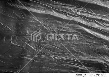 Subtle dark plastic surface with soft wrinkles, minimal abstract background. 135794836