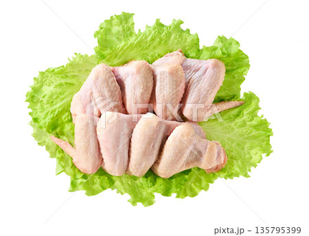 fresh raw chicken wings with lettuce isolated on a white background, top view. 135795399