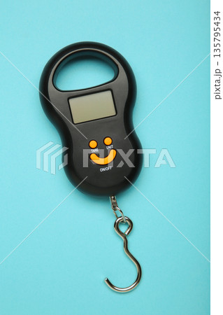 Small portable electronic scale on blue background. Vertical photo 135795434