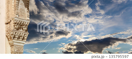Columns in Islamic (Moorish) style in Alhambra (against the background of a beautiful sky with clouds), Granada, Spain Columns in Islamic (Moorish) style in Alhambra (against the background of a beautiful sky with clouds), Granada, Spain 135795597