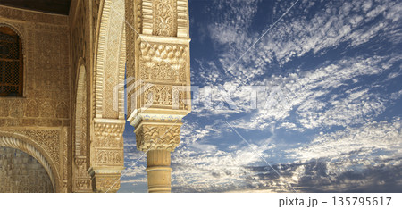 Columns in Islamic (Moorish)  style in Alhambra (against the background of a beautiful sky with clouds), Granada, Spain 135795617