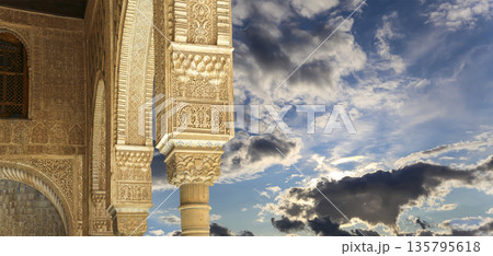 Columns in Islamic (Moorish) style in Alhambra (against the background of a beautiful sky with clouds), Granada, Spain Columns in Islamic (Moorish) style in Alhambra (against the background of a beautiful sky with clouds), Granada, Spain 135795618