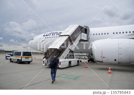 Frankfurt, Germany, June 10, 2019: Long Haul Aircraft Boarding via Staircase on the Apron on a Summer Day Frankfurt, Germany, June 10, 2019: Long Haul Aircraft Boarding via Staircase on the Apron on a Summer Day 135795843