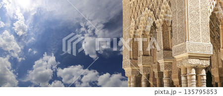 Columns in Islamic (Moorish)  style in Alhambra (against the background of a beautiful sky with clouds), Granada, Spain 135795853