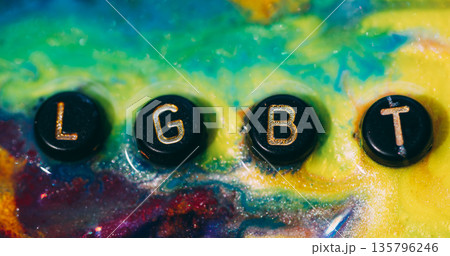 Lgbt word. Glitter ink. Defocused yellow blue purple color sparkling letters tolerance splatter pride particle black texture on abstract art background. Lgbt word. Glitter ink. Defocused yellow blue purple color sparkling letters tolerance splatter pride particle black texture on abstract art background. 135796246