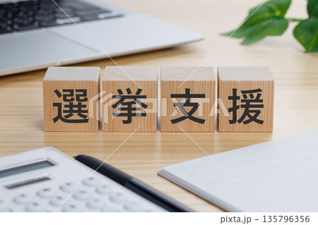 テーブルの上に選挙支援と書かれたブロック 135796356