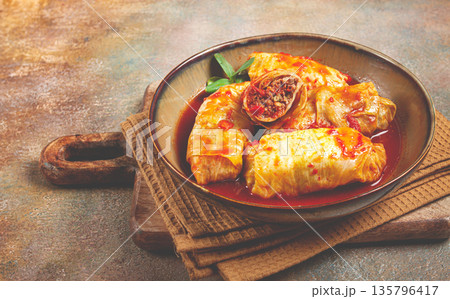 Stuffed cabbage rolls with minced meat, in tomato sauce, top view, without people, in the spotlight. 135796417