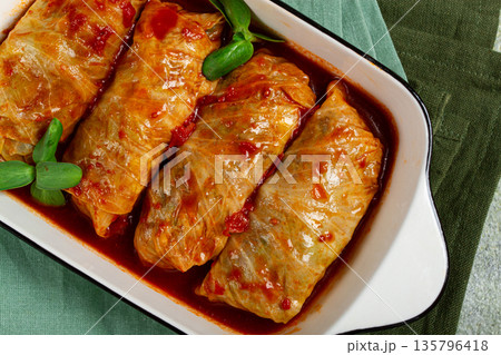 Stuffed cabbage rolls with minced meat, in tomato sauce, top view, without people, in the spotlight. 135796418
