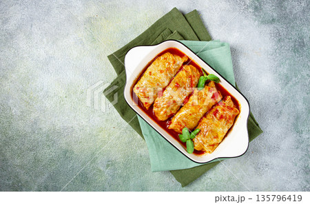 Stuffed cabbage rolls with minced meat, in tomato sauce, top view, without people, in the spotlight. Stuffed cabbage rolls with minced meat, in tomato sauce, top view, without people, in the spotlight. 135796419