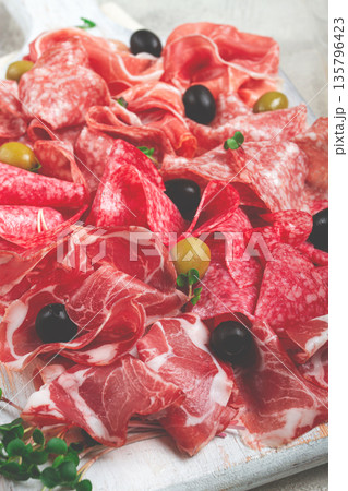 Assorted, meat appetizer, prosciutto, salami and ham, with olives , close-up, breakfast, top view, close-up, without people 135796423
