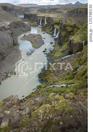 Vertical shot of river valley with multiple waterfalls streaming into it, Highlands, Iceland Vertical shot of river valley with multiple waterfalls streaming into it, Highlands, Iceland 135796530