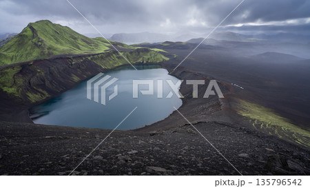 Vast volcanic landscape with mountains and craters with cars travelling through, Highlands, Iceland 135796542