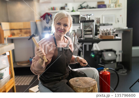Woman jeweler working in workshop crafting new jewelry Woman jeweler working in workshop crafting new jewelry 135796600