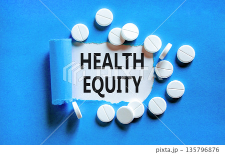 Health equity symbol. Concept words Health equity on beautiful white paper. White pills tablets. Beautiful blue background. Medical healthy lifestyle health equity concept. 135796876