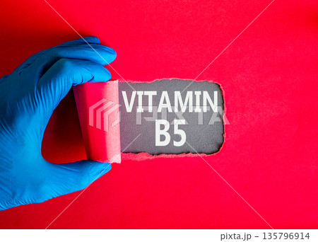 Vitamin B5 pantothenic acid symbol. Concept words Vitamin B5 on beautiful grey paper. Doctor hand in blue medical glove. Beautiful red background. Medical healthy lifestyle Vitamin B5 concept. Vitamin B5 pantothenic acid symbol. Concept words Vitamin B5 on beautiful grey paper. Doctor hand in blue medical glove. Beautiful red background. Medical healthy lifestyle Vitamin B5 concept. 135796914